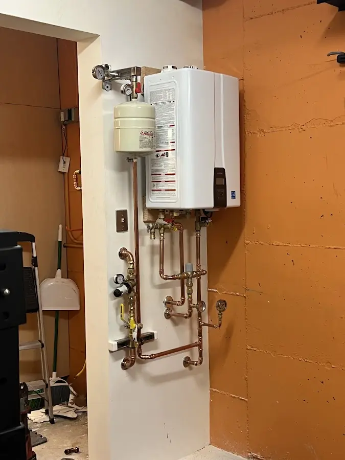 Plumbing technician inspecting water heater connections in Wilkes-Barre